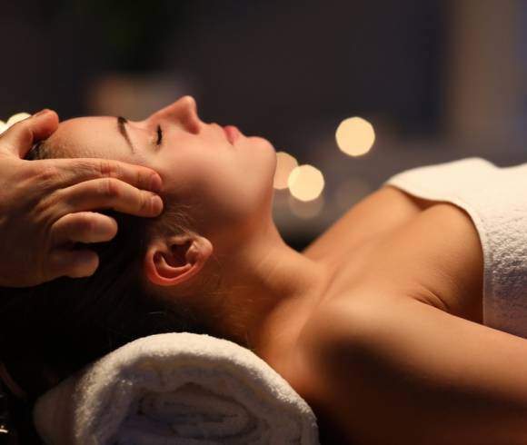 Close-up of a woman receiving a relaxing Ayurvedic head massage.