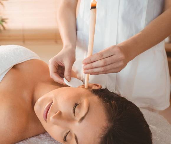 Application of a traditional ear candle therapy to relieve discomfort in the forehead, throat, ear and sinus area.
