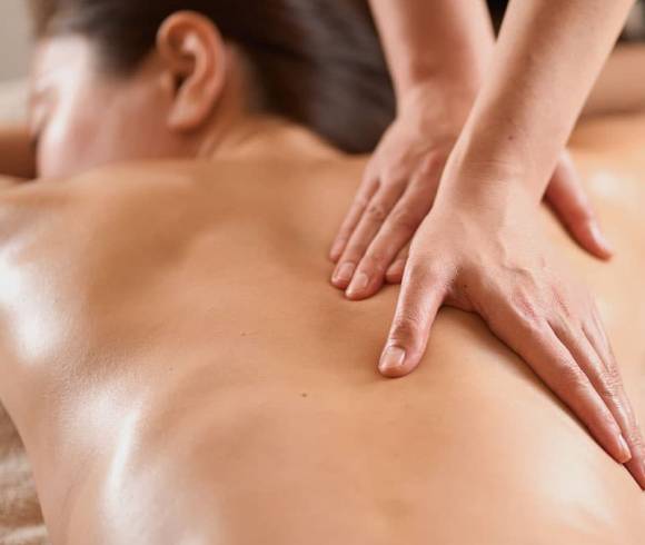 Relaxing Ayurveda massage with medicinal herbal oil on the back of a guest.