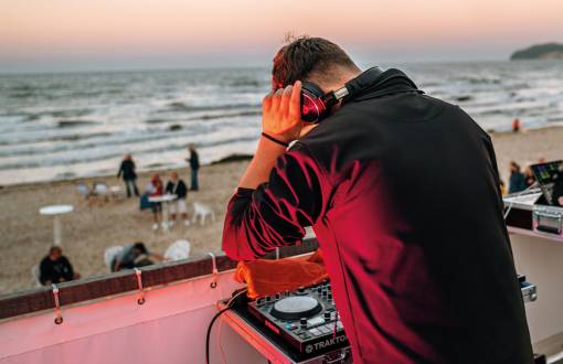 Nahaufnahme eines DJs, der auf der Saisonabschluss-Party am Strand vor dem Grand Hotel Binz auflegt und für Stimmung sorgt.
