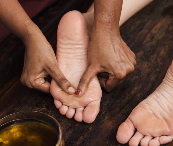 Gentle stroking movements with massage oil on the underside of the feet.