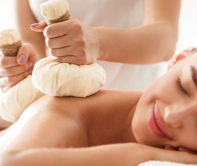 Eine Frau entspannt bei einer ayurvedischen Massage im Wellnessbereich des Grand Hotel Binz mit vielen Ayurveda-Angeboten.