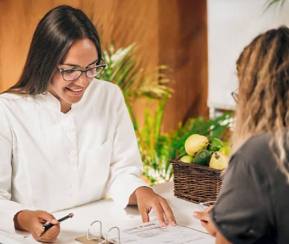An Ayurveda doctor advises her client on the basis of documents.