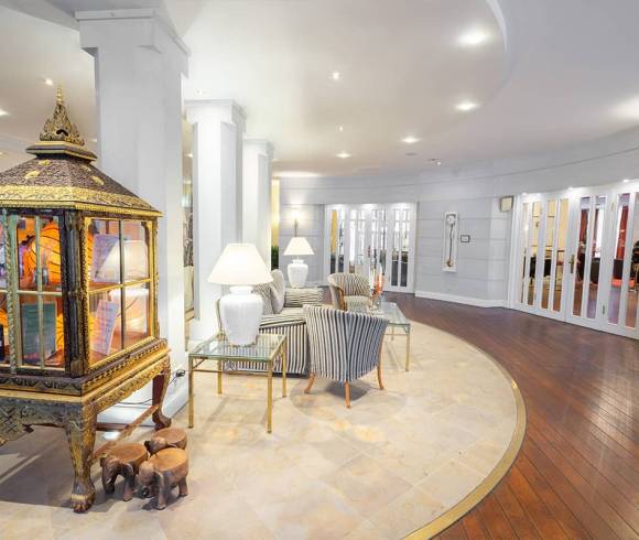 A seating area with sofa and armchairs in bright colors in front of the reception at the Grand Hotel Binz.