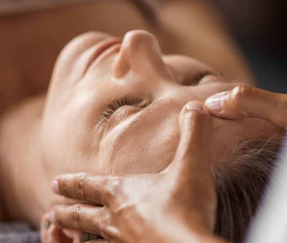 Targeted, soothing massage techniques on the head of a relaxed guest.
