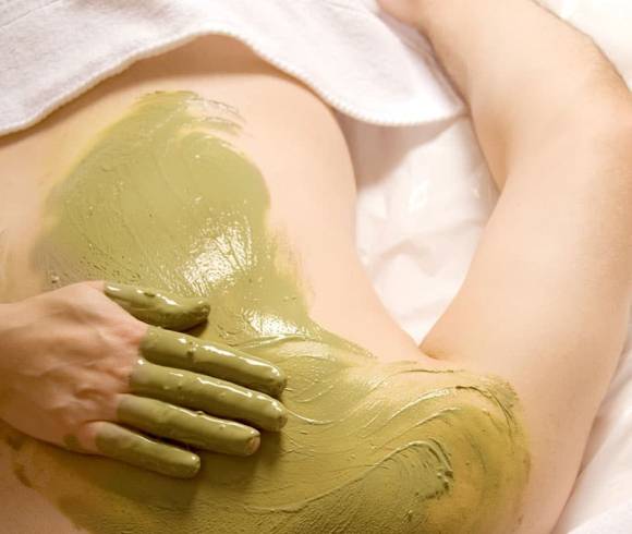 Application of a detoxifying herbal paste on the back.