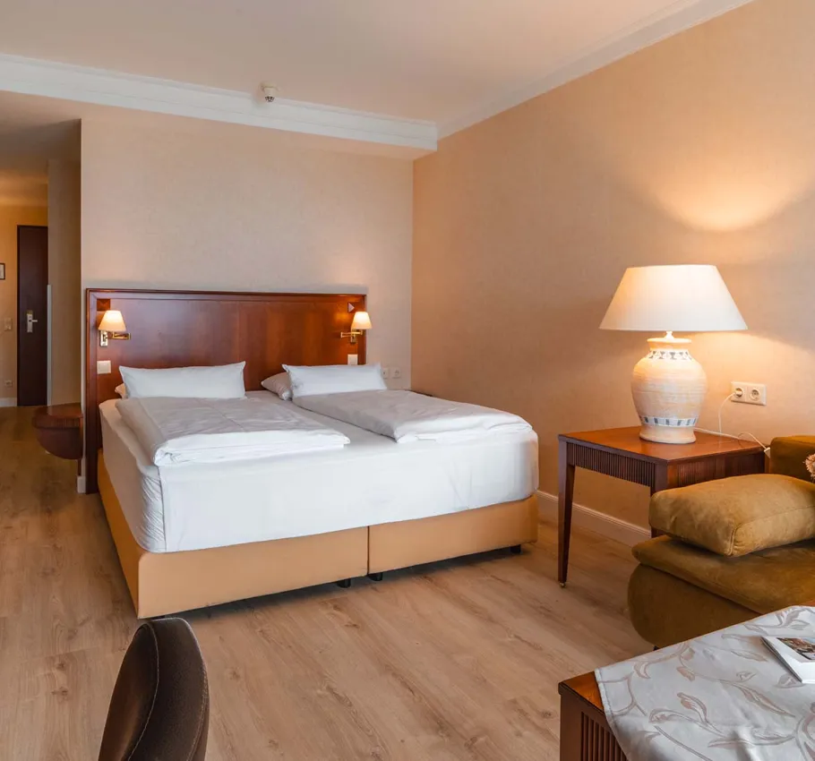 Komfortables Baltic Deluxe Zimmer im Grand Hotel Binz mit gemütlicher Sitzecke, Balkon und Ostseepanorama.