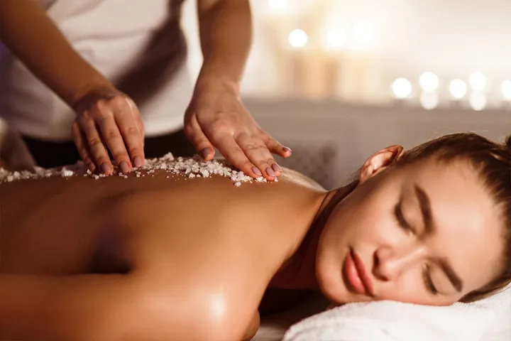 Woman relaxes during a massage with sea salt in the Well-Being Spa at the Grand Hotel Binz on Rügen.