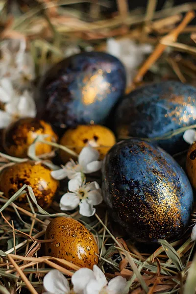 Gold-blaue Ostereier in einem Nest aus Stroh im Grand Hotel Binz, passend zu den Feiertagsangeboten.