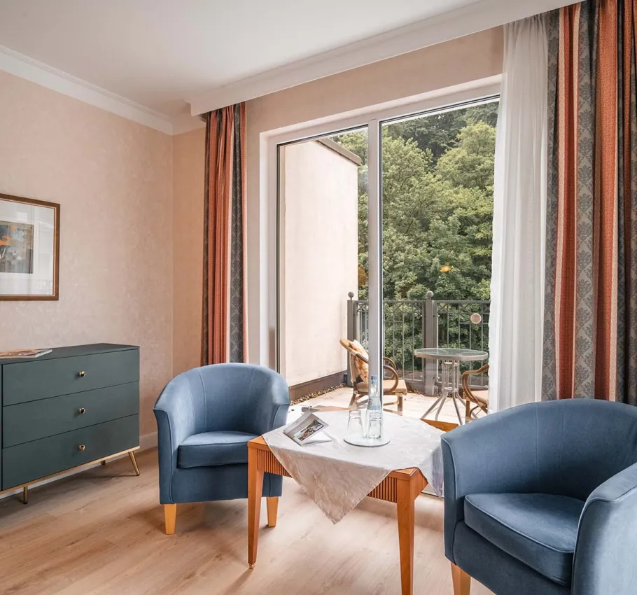 Elegantes Granitz Deluxe Zimmer im Grand Hotel Binz mit Dachterrasse, Loungemöbeln und Blick ins Grüne.