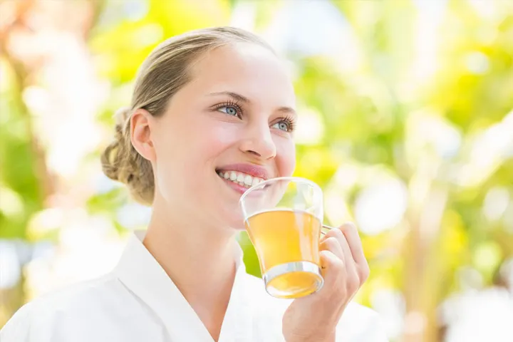 A happy woman drinks a delicious tea while fasting on a wellness vacation on Rügen at the Grand Hotel Binz.