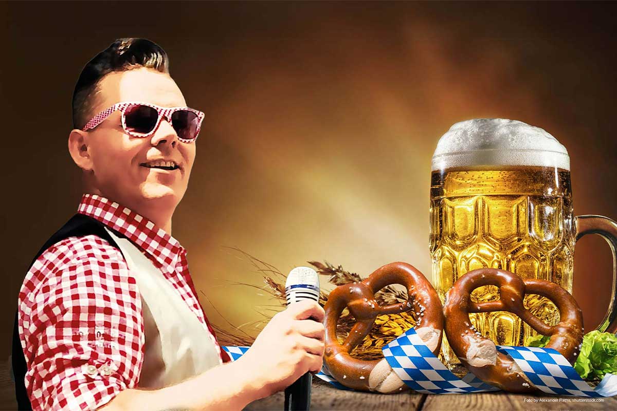 Sänger in Tracht mit Mikrofon und Sonnenbrille beim Binzer Oktoberfest in der nähe des Grand Hotel Binz auf Rügen.