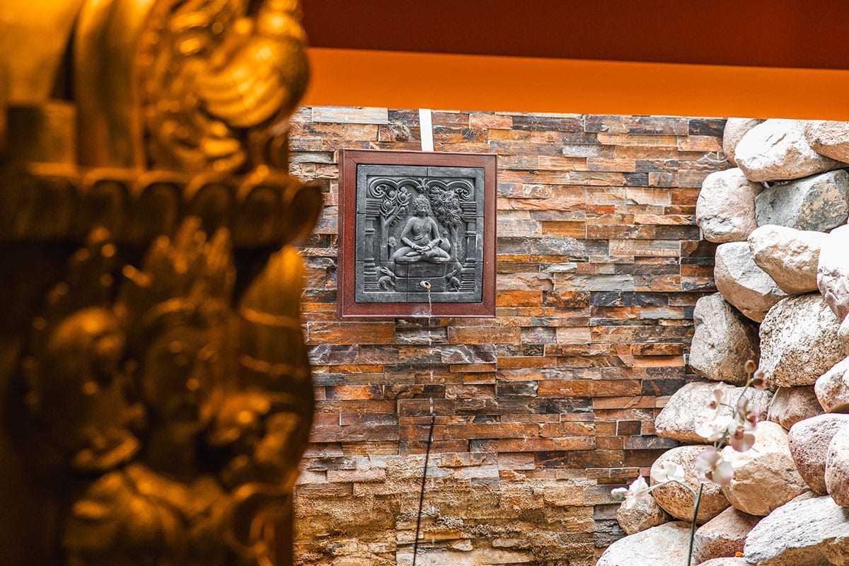 Spirituelles Spa-Design mit Buddha-Relief, Natursteinen und warmem Licht